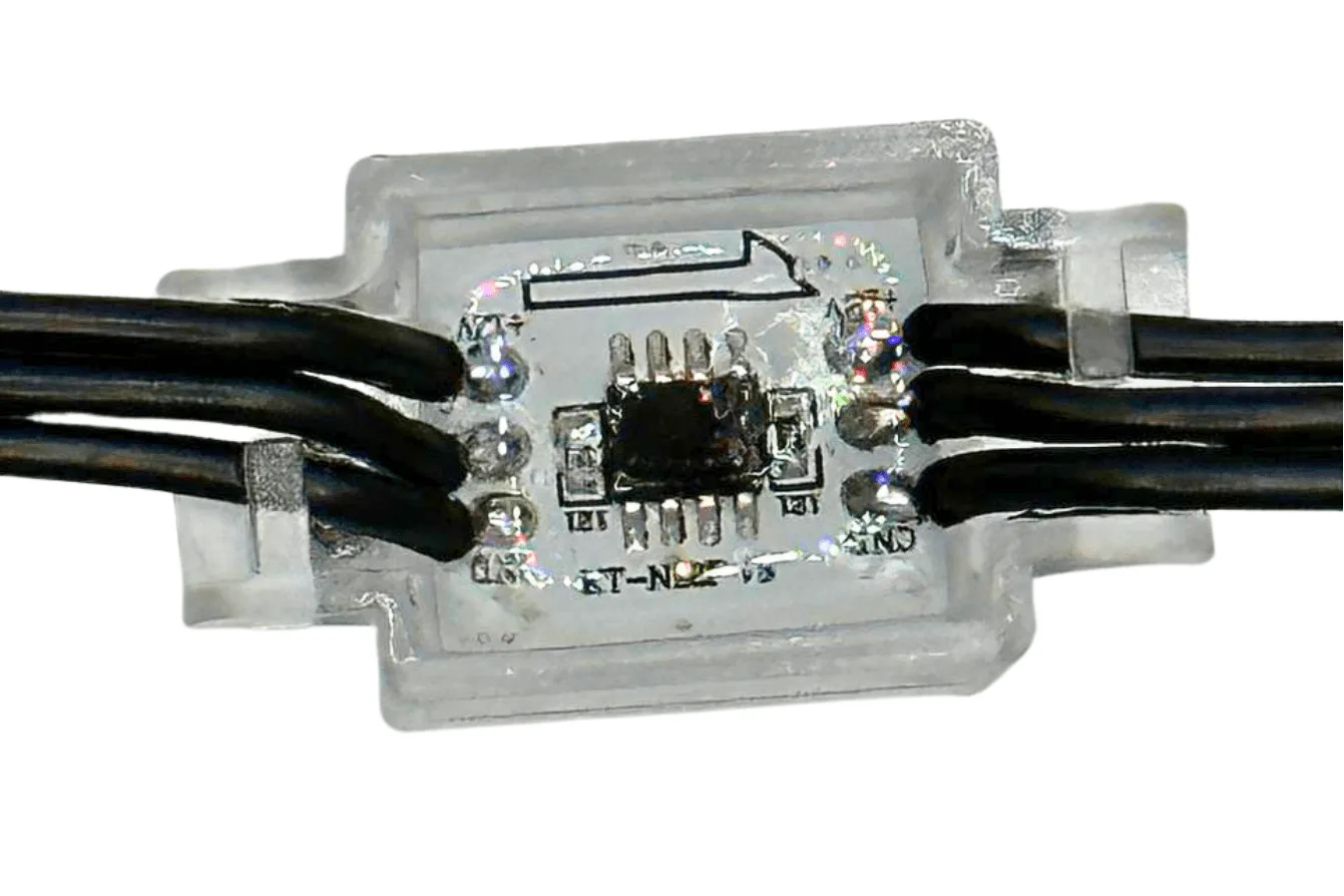 Attached image file Close-up of a small electronic circuit encased in clear plastic, with black wires connected on both sides. A microchip and several solder points are visible inside the casing.